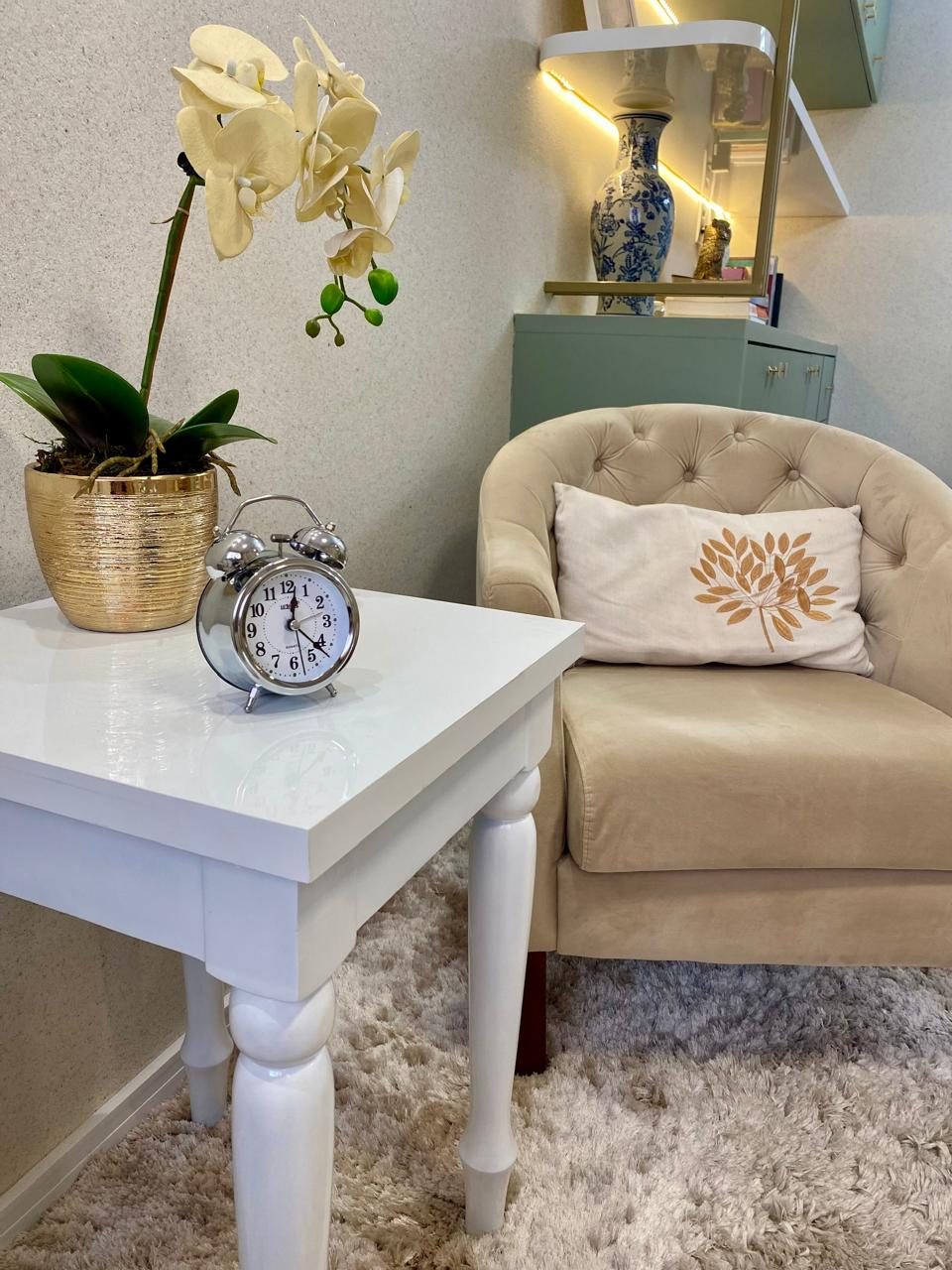 Detalhe do consultório de psicologia em Parnamirim-RN: poltrona, orquídea e relógio sobre mesa lateral
